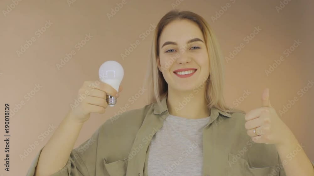 Young cute woman with electric bulb, studio Young cute woman with electric bulb, studio
