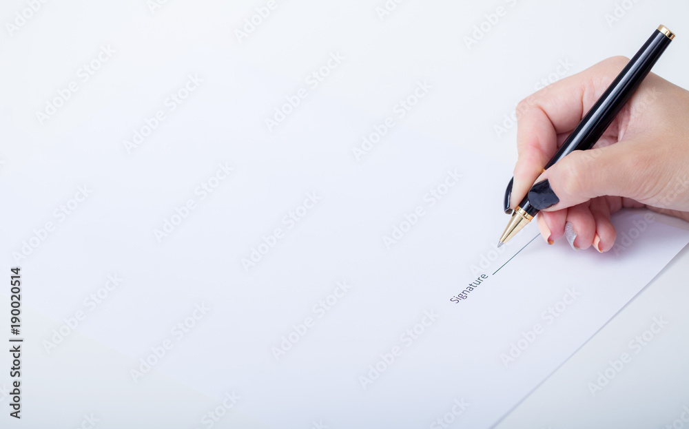 Close up girl hand putting signature on document. She situating at desk. Business concept. Low angle Close up girl hand putting signature on document. She situating at desk. Business concept. Low angle