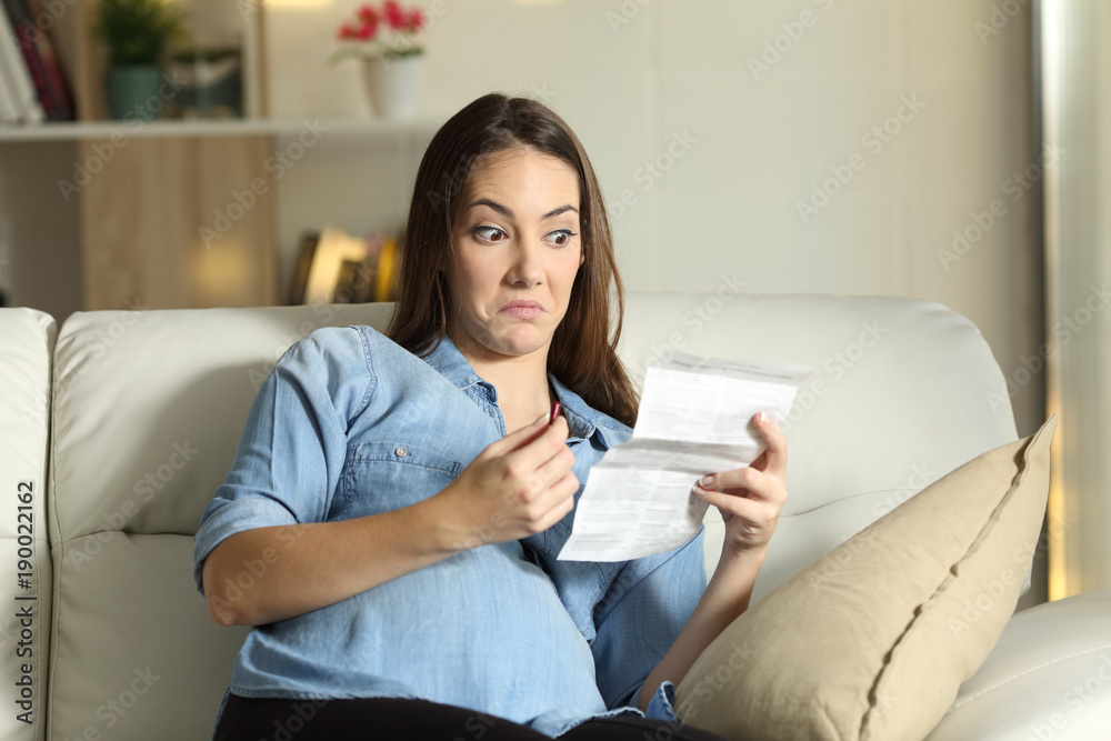 Distrustful pregnant lady reading a leaflet before take a pill Distrustful pregnant lady reading a leaflet before take a pill