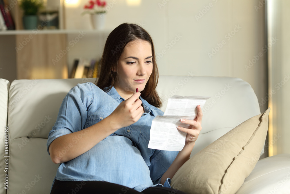 Pregnant woman reading a leaflet before take a pill Pregnant woman reading a leaflet before take a pill
