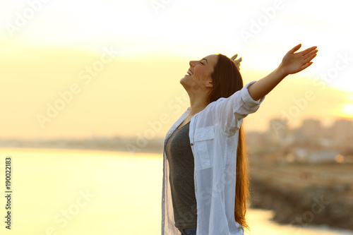 Profile of a woman breathing fresh air at sunset