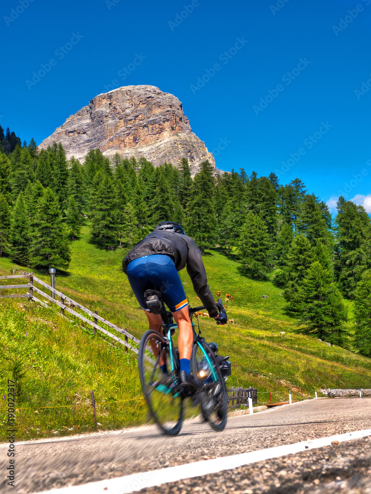 Rennradfahrer fährt Dolomiten-Passstrasse hinauf Rennradfahrer fährt Dolomiten-Passstrasse hinauf