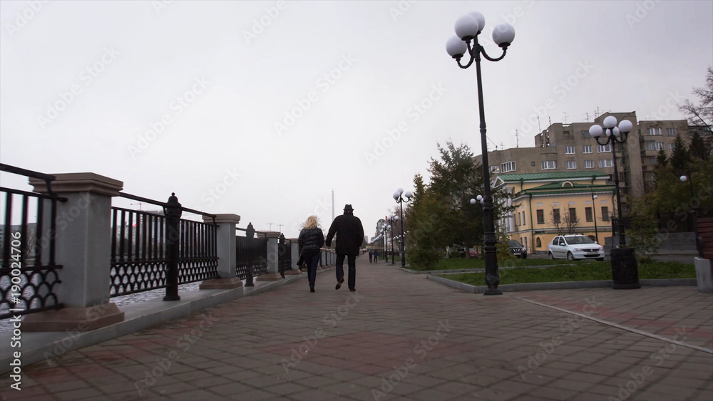 Romantic couple walking together. Video. An elderly couple walks in the city on a cloudy day. Timelapse