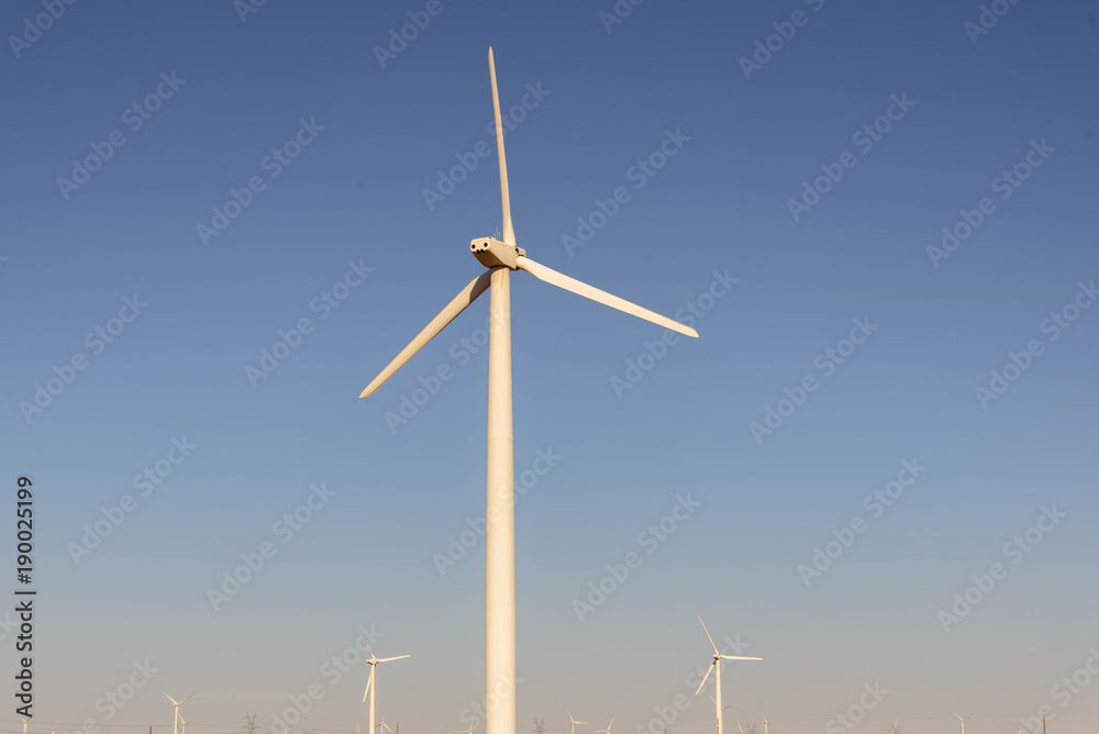 wind turbines in the desert with a blue sky