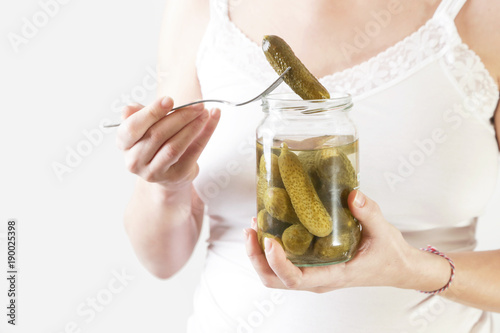 Pregnant woman holding jar of pickles - pregnancy food craving concept photo