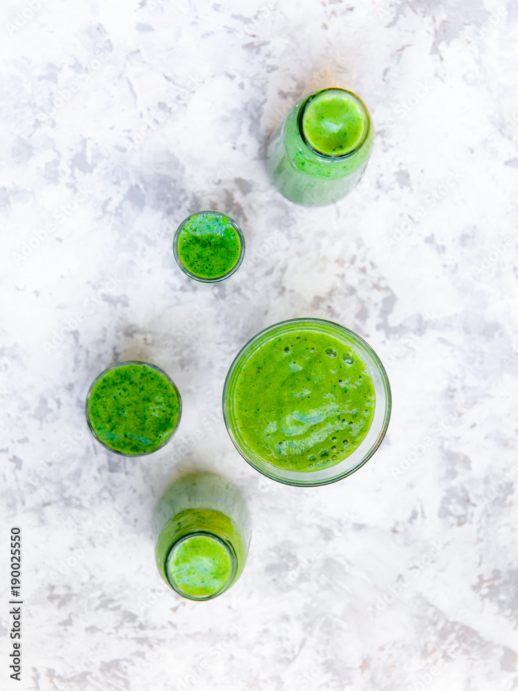 Still life of green smoothie in glass on white textured background. Healthy lifestyle concept. Still life of green smoothie in glass on white textured background. Healthy lifestyle concept.