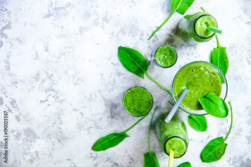 Still life of green smoothie in glass on white textured background. Healthy lifestyle concept. © yolya_ilyasova