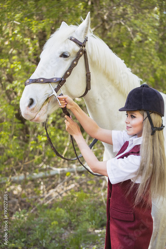 Autumn landscape, beautiful brunette girl with long hair posing with a red horse in the forest photo