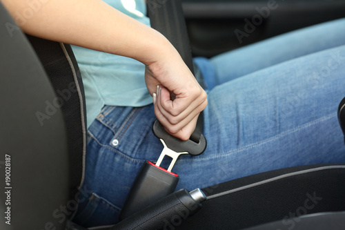 Driver hand fastening seatbelt in a car