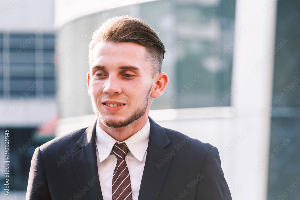 Portrait of handsome man in black suit standing outdoors Portrait of handsome man in black suit standing outdoors