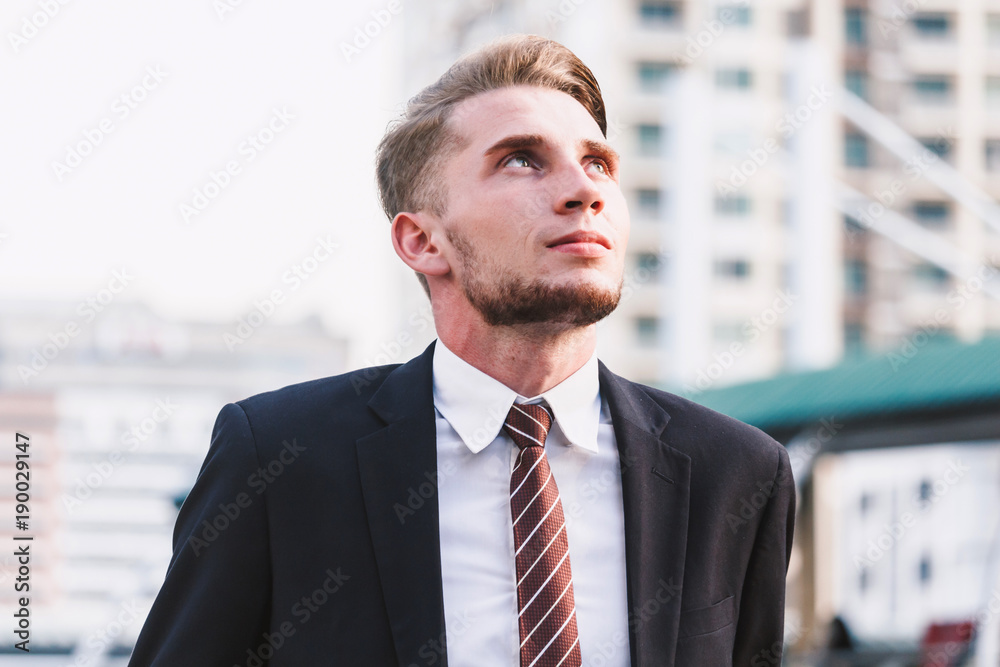 Portrait of handsome man in black suit standing outdoors Portrait of handsome man in black suit standing outdoors