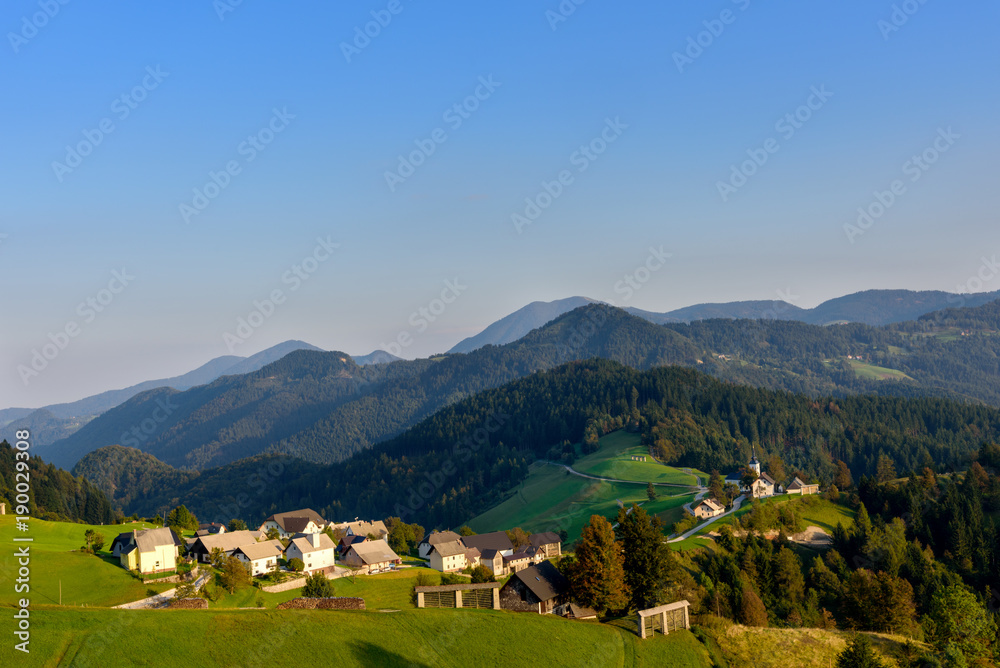 Countryside village in Slovenia sunset view, idyllic rolling green hills