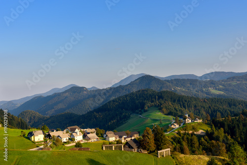 Countryside village in Slovenia sunset view, idyllic rolling green hills