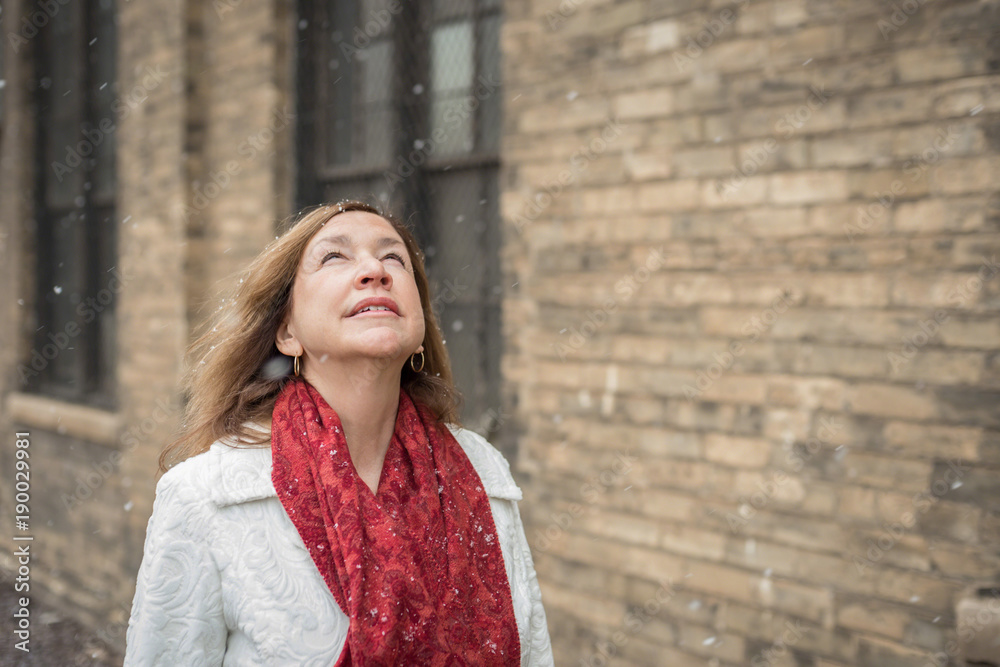 urban woman looking up at snow falling urban woman looking up at snow falling