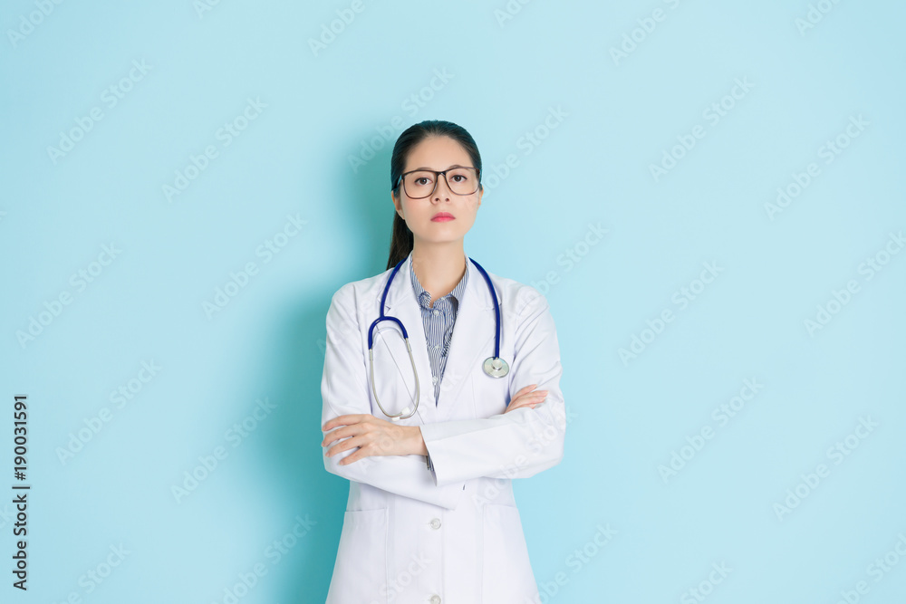 hospital doctor standing in blue wall background hospital doctor standing in blue wall background