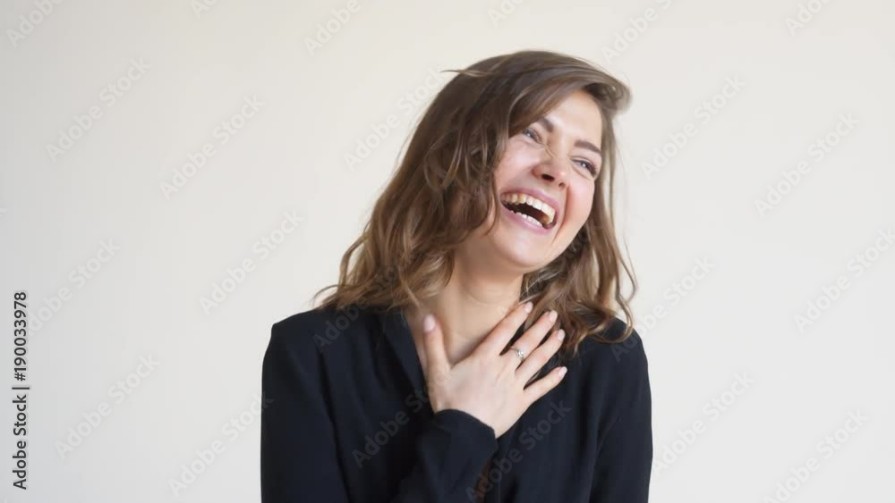 Young woman laughing at joke during conversation with someone Young woman laughing at joke during conversation with someone