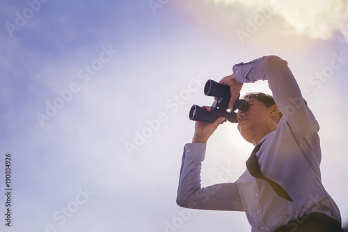 Close up of Businessman looking through binocular. searching for goal concept. low angle view.