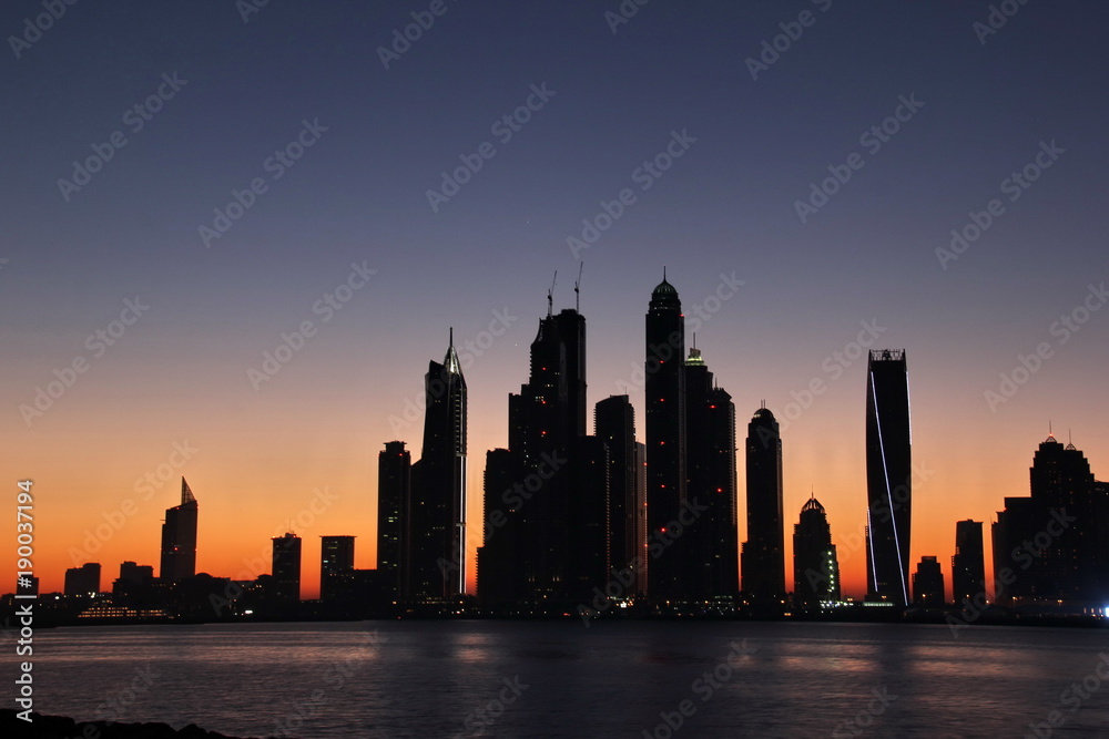 skyline of Dubai Marina, famous skyscrapers and luxury hotels in this area, under sunset