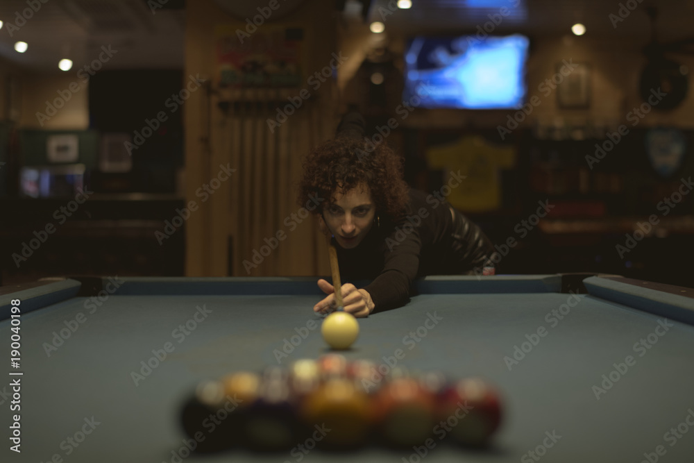 Fotografie Woman playing pool at a bar