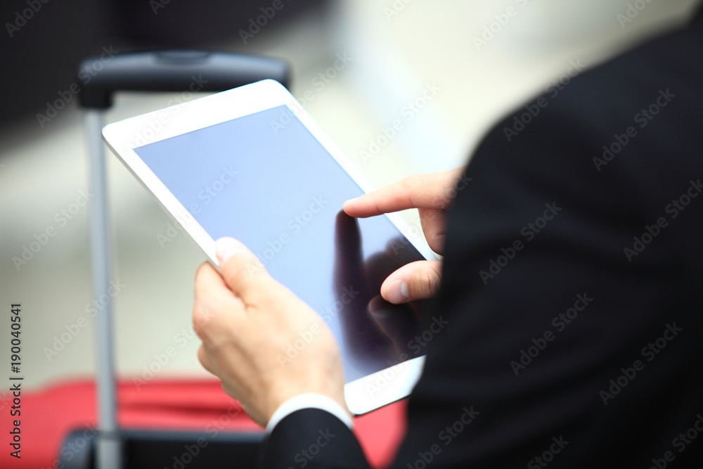 Businessman Using Digital Tablet In Airport Departure Lounge Businessman Using Digital Tablet In Airport Departure Lounge
