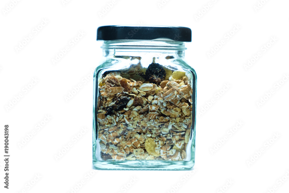 Granola or muesli in glass jar on white background Granola or muesli in glass jar on white background