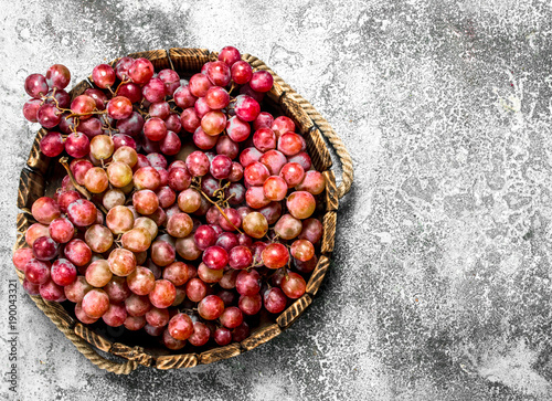 Red grapes on a wooden tray.