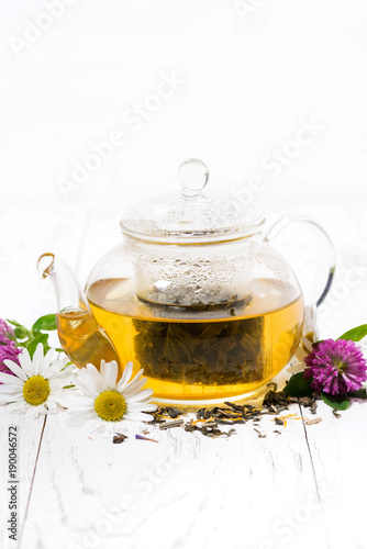 fragrant herbal tea in a teapot on white wooden background, vertical