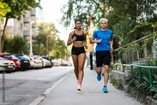 Athletic mixed race couple running outdoors