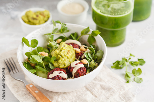 фотографія Green vegetable vegan salad with beets meatballs, Guacamole, tahini dressing and green juice