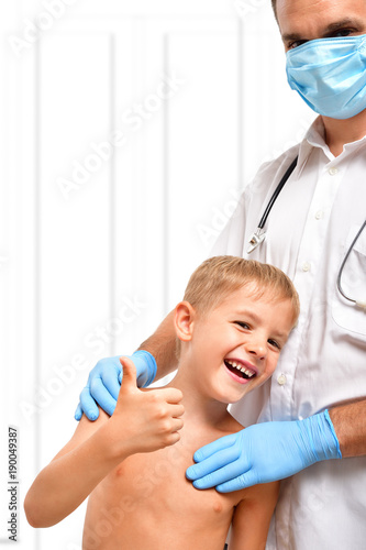 Portrait of a cheerful child standing next to a doctor
