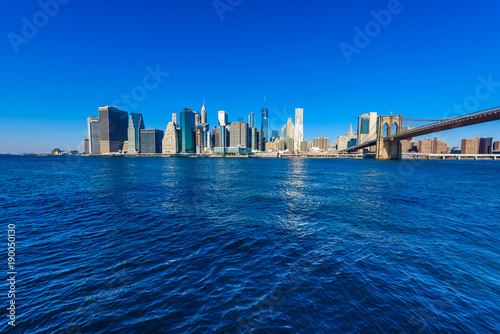 Brooklyn Bridge and the Lower Manhattan skyline panorama from Brooklyn Bridge Park riverbank, New York City, USA