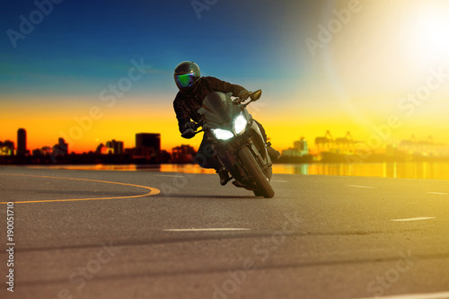 man riding sport motorcycle leaning in sharp curve with traveling scene background © stockphoto mania