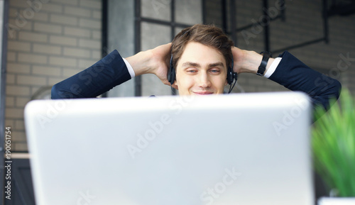 Smiling friendly handsome young male call centre operator.