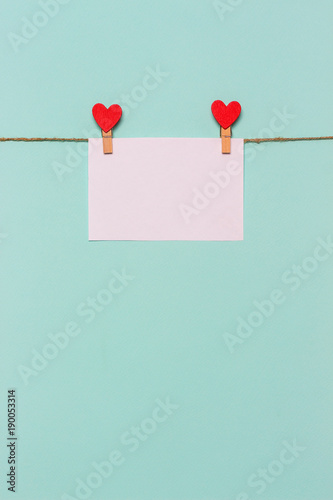 white piece of paper pinned to rope with clothespin decorated with wooden heart