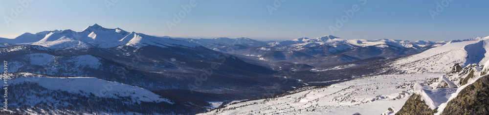 Winter mountain landscape overlooking the of the forest valley. 