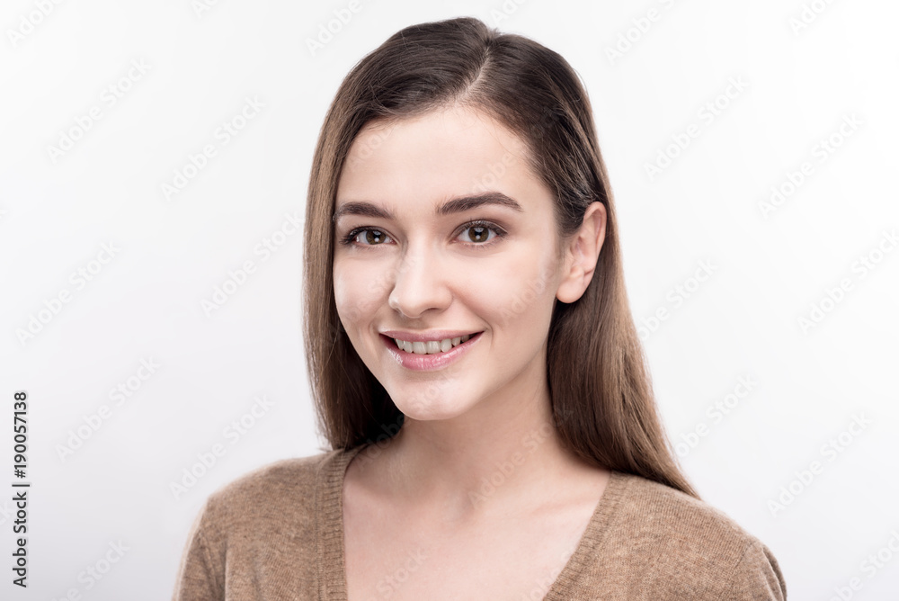 Ethereal beauty. The portrait of a beautiful dark-eyed young woman smiling at the camera while posing isolated on a white background Ethereal beauty. The portrait of a beautiful dark-eyed young woman smiling at the camera while posing isolated on a white background