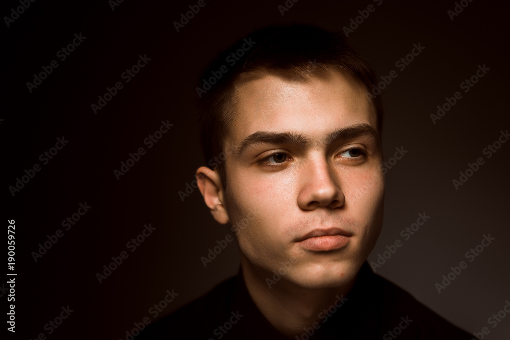 young guy on a dark studio background young guy on a dark studio background