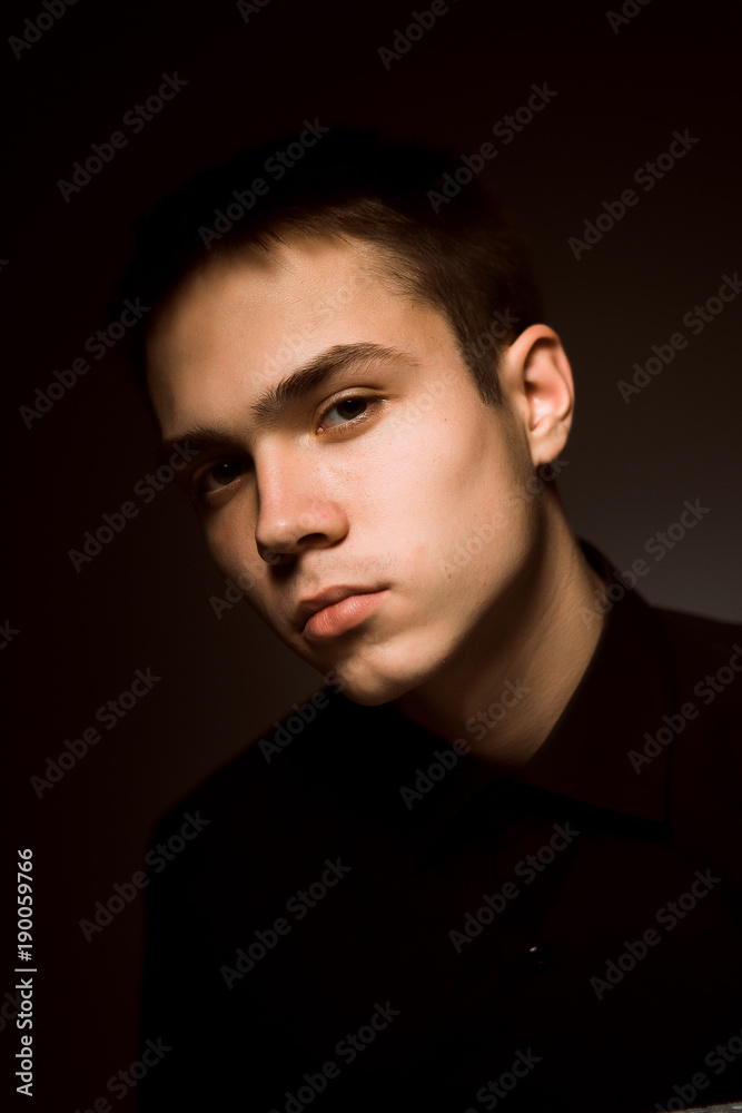 young guy on a dark studio background