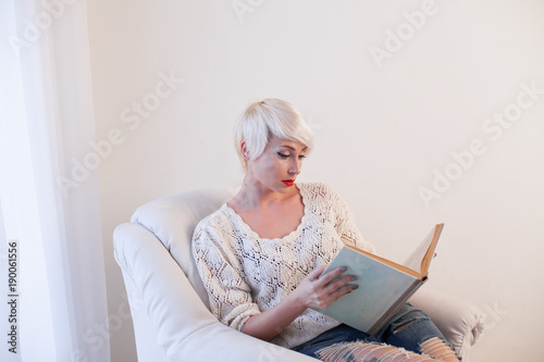 blonde girl reading a book is preparing