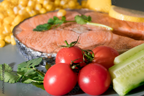 fresh tomato on the grilled fish salmon fillet dish, food and vegetable concept