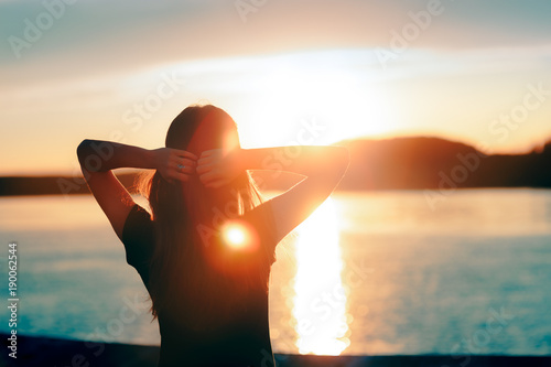 Happy Hopeful Woman Looking at the Sunset by the Sea photo