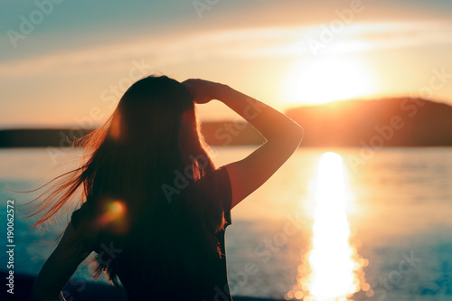 Fototapeta Happy Hopeful Woman Looking at the Sunset by the Sea