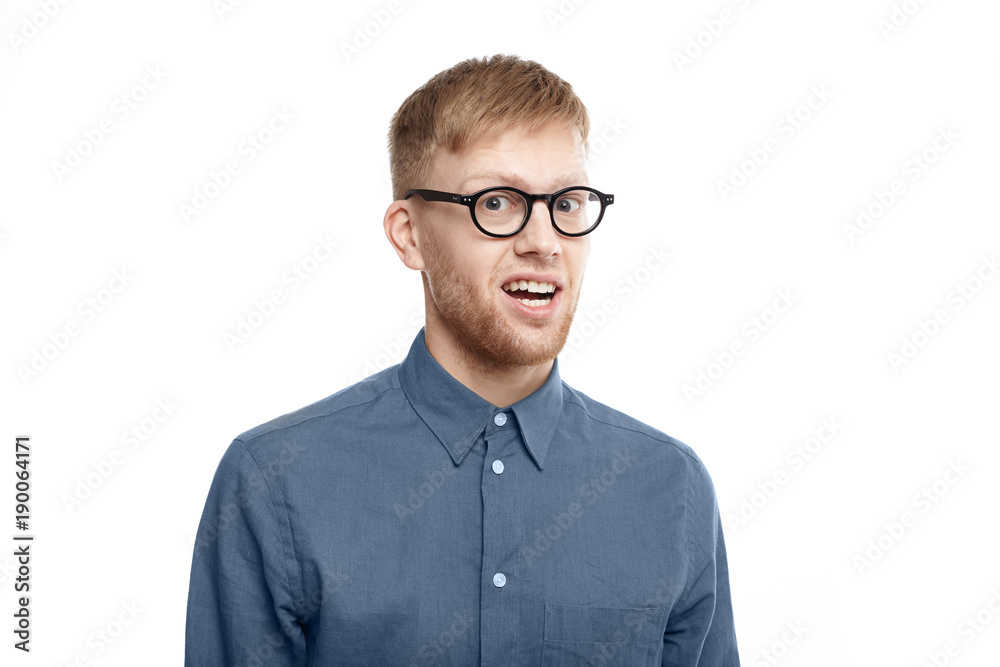 Picture of funny emotional young unshaven man wearing stylish glasses opening mouth in astonishment, being shocked with unexpected news, staring at camera in full disbelief. Shock and surprise Picture of funny emotional young unshaven man wearing stylish glasses opening mouth in astonishment, being shocked with unexpected news, staring at camera in full disbelief. Shock and surprise