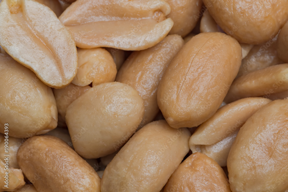 Shelled roasted peanuts close-up as textured background