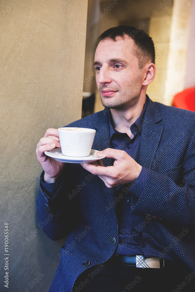 The man sits in cafe with a cup of coffee The man sits in cafe with a cup of coffee