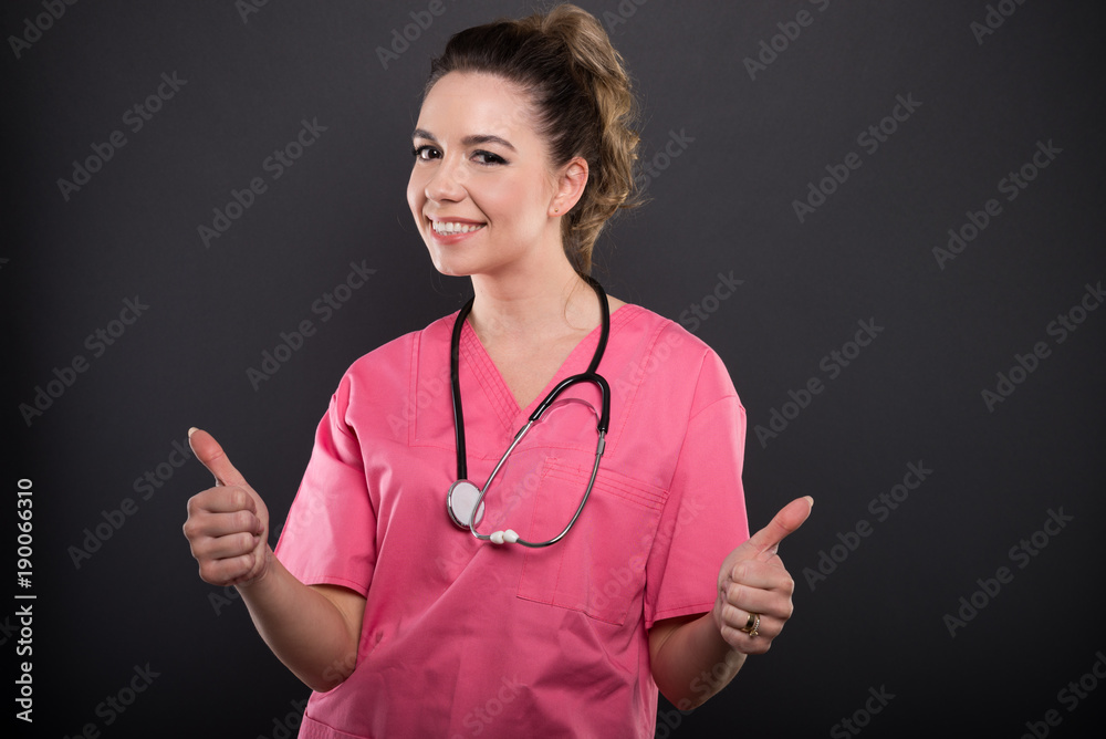 Portrait of attractive lady doctor showing double like gesture Portrait of attractive lady doctor showing double like gesture