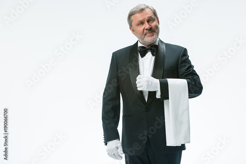 Senior waiter holding white towel
