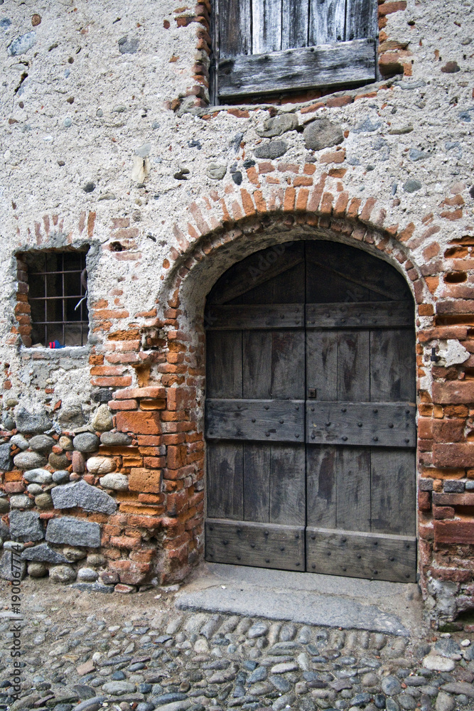 L'antico portone in legno massiccio , nella casa del borgo medievale L'antico portone in legno massiccio , nella casa del borgo medievale