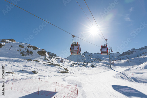 Cableway lift cable cars, gondola cabins on winter snowy mountains background beautiful scenery.