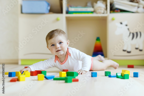 Cute baby girl playing with colorful rattle toys